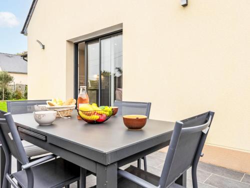 - une table et des chaises avec des bols de fruits dans l'établissement Holiday Home Clos Miroir by Interhome, à Cancale