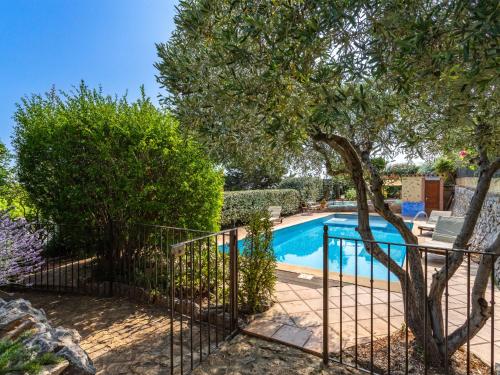 a villa with a swimming pool and a tree at Apartment Mimosas by Interhome in Carqueiranne