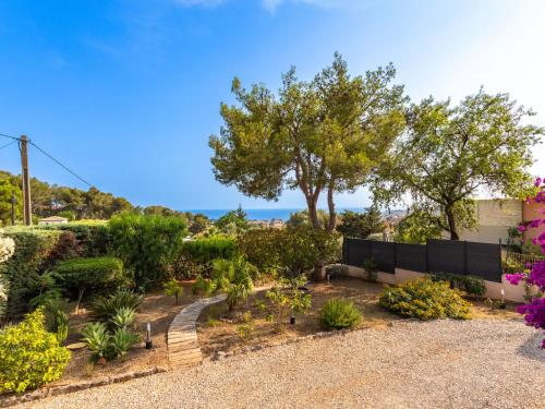 a garden with plants and trees and a fence at Apartment Mimosas by Interhome in Carqueiranne