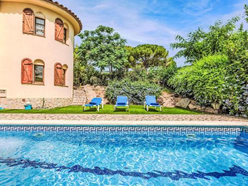 a house with two chairs and a swimming pool at Holiday Home Villa Brava by Interhome in Calonge