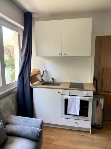 une petite cuisine avec un évier et une cuisinière dans l'établissement T2 à Ambilly à 200m du tram 17, à Ambilly