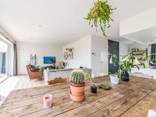a living room with potted plants on a wooden table at Villa Villa Vosseslag - garage and big garden by Interhome in De Haan