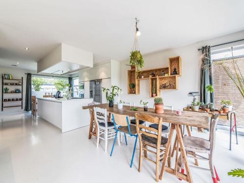 a kitchen and dining room with a wooden table and chairs at Villa Villa Vosseslag - garage and big garden by Interhome in De Haan