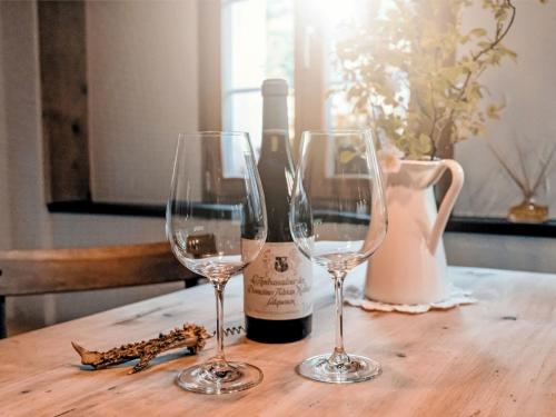 a table with two wine glasses and a bottle of wine at Apartment Chalet Solegg by Interhome in Innertkirchen