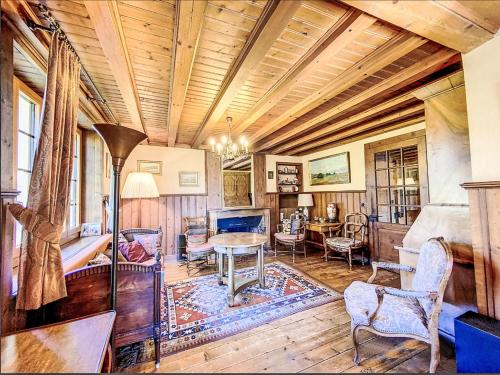 a living room with a wooden ceiling and a table and chairs at Chalet Sergnoud by Interhome in Lens