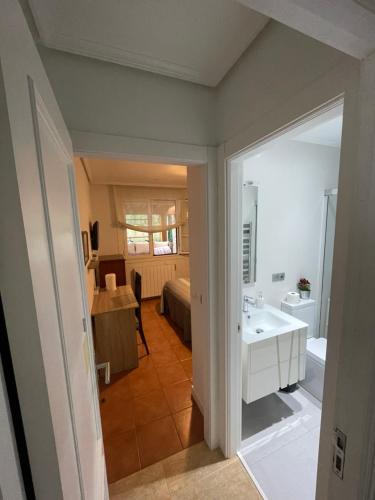 a bathroom with a white sink and a room at Habitación con baño privado y jardín Cerca de las playas in Boó de Piélagos
