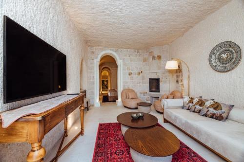 a living room with a large flat screen tv at Via Regia Cappadocia Hotel in Uchisar