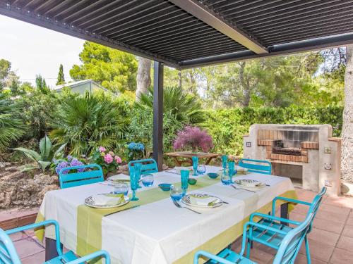 a table and chairs on a patio with a grill at Villa Platja Calafato by Interhome in L'Ametlla de Mar