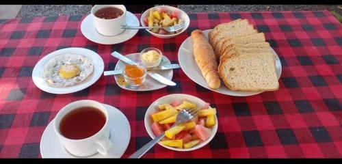 a table with plates of food and cups of coffee at Bakery Family Guest House in Mirissa