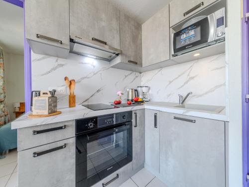 une cuisine avec une cuisinière et un évier dans l'établissement Apartment Les Floralies II-15 by Interhome, au Grau-du-Roi