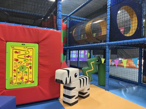 einen Spielbereich mit einem Spielzeugelefant und einem Spielplatz in der Unterkunft Holiday Home Noordzee Deluxe 32 by Interhome in Scherpenisse