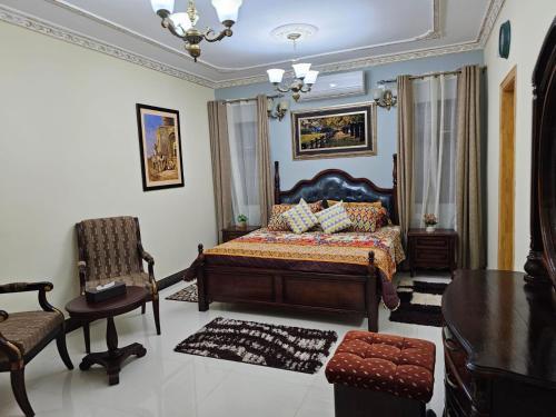 a bedroom with a bed and a chair and a table at Blue Rawal in Bain Boeuf