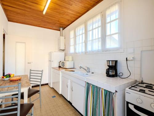 Il comprend une cuisine équipée d'un évier, d'une cuisinière et d'une table. dans l'établissement Holiday Home L'astérie by Interhome, à Mimizan