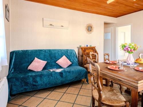 un salon avec un canapé bleu et une table dans l'établissement Holiday Home L'astérie by Interhome, à Mimizan