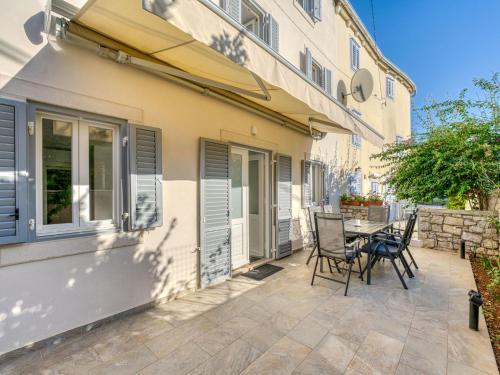a patio with chairs and a table next to a building at Holiday Home Tanja by Interhome in Osor