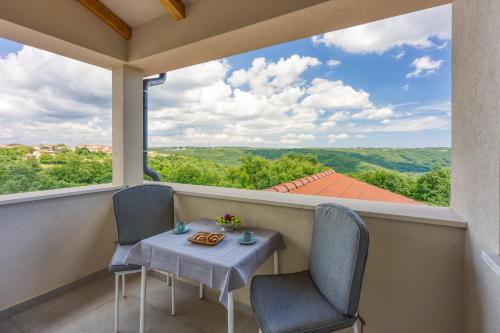 a table and chairs on a balcony with a view at LOVOR - Relax in Greenery & Explore Istria in Tinjan