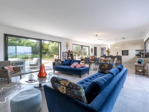 een woonkamer met twee blauwe banken en een keuken bij Villa Villa Lamas by Interhome in Sainte-Lucie de Porto-Vecchio