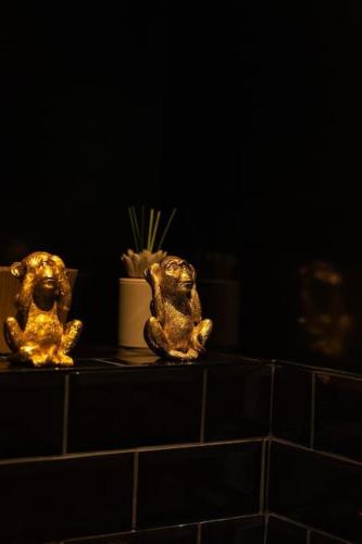 two gold statues sitting on a counter in a bathroom at La Royale Room in Épernay