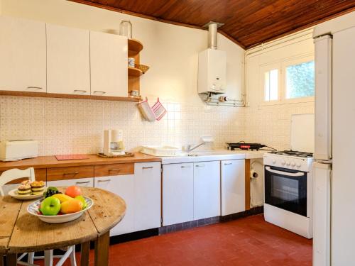 une cuisine avec une table avec un bol de fruits dessus dans l'établissement Holiday Home Rêve d'été by Interhome, à Mimizan