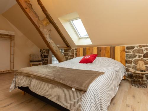 une chambre avec un lit avec un oreiller rouge dessus dans l'établissement Holiday Home Tiegezh by Interhome, à Cherrueix