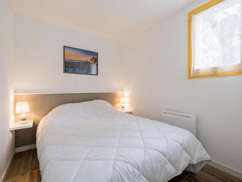 une chambre avec un lit blanc et une fenêtre dans l'établissement Holiday Home Les Charmilles-13 by Interhome, à La Palmyre