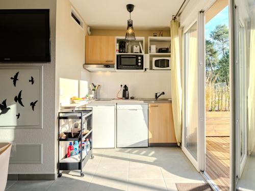 eine kleine Küche mit Spüle und Mikrowelle in der Unterkunft Apartment Soleil couchant by Interhome in Mimizan