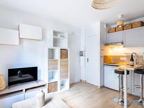 une cuisine avec des armoires blanches et une table dans l'établissement Studio Villa Theleme by Interhome, à Toulon