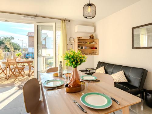 ein Esszimmer mit Tisch und Couch in der Unterkunft Apartment Soleil couchant by Interhome in Mimizan