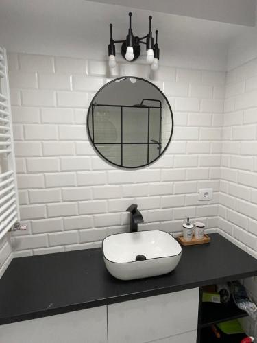 a bathroom with a white sink and a mirror at Sofia TS apartment in Craiova