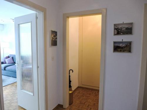 a hallway with a yellow door and a blue couch at Apartment Marigny Dent-Blanche 25 by Interhome in Crans-Montana