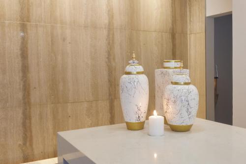 two vases sitting on a table with a candle at The HEALTHY Stay-Padel, Pool&Fitness in Ayia Napa