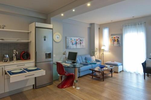 ein Wohnzimmer mit einem Sofa und einem Tisch mit einem Laptop in der Unterkunft Acropolis Luxury Apartment with Balcony in Athen