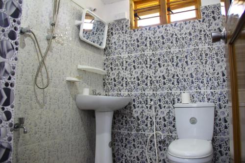a bathroom with a toilet and a sink and a shower at Kandy Little White House in Kandy