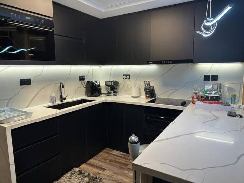 a kitchen with black cabinets and white counter tops at Upgraded Studio at Bab Al Bahr in Ras al Khaimah