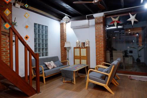 a living room with a couch and chairs at Mekong view House in Luangprabang in Luang Prabang