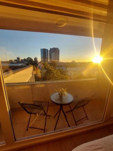 a table and chairs on a balcony with a view at Departamento en Chillán Centro in Chillán
