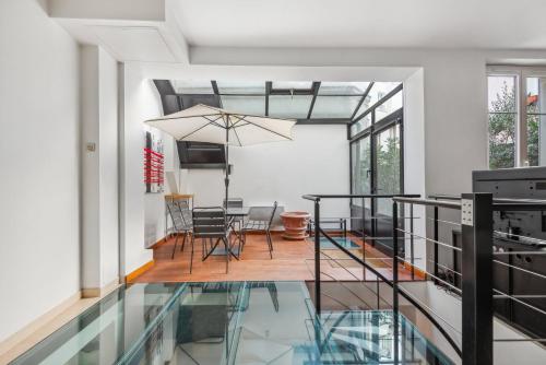 une pièce avec un sol en verre et une salle à manger dans l'établissement Loft de 80 m² avec jardin privatif, à Paris