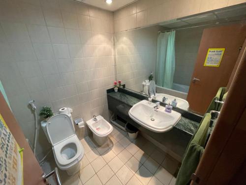 ein Badezimmer mit Toilette, Waschbecken und Spiegel in der Unterkunft Travelers backpackers in Dubai