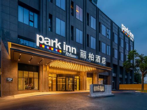 ein Gebäude mit einem Schild an der Vorderseite in der Unterkunft Park Inn by Radisson Nanjing North Zhongshan Road in Nanjing