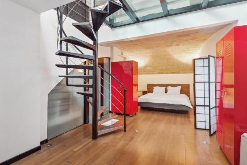 - un escalier en colimaçon dans une chambre avec un lit dans l'établissement Loft de 80 m² avec jardin privatif, à Paris