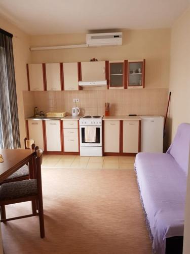 a small kitchen with white cabinets and a stove at Apartment Mari in Lopar