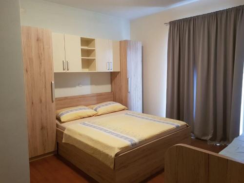 a bedroom with a bed with a wooden headboard at Apartment Mari in Lopar
