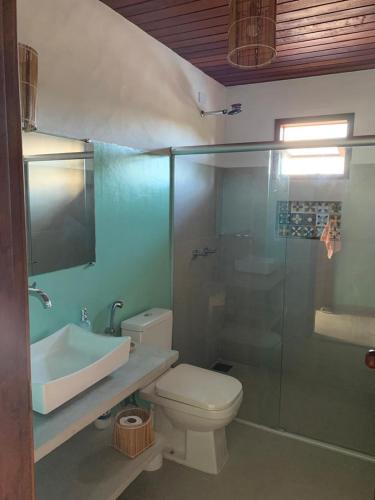 a bathroom with a toilet and a sink and a shower at Vila Sol Chalés in Pôrto de Pedras