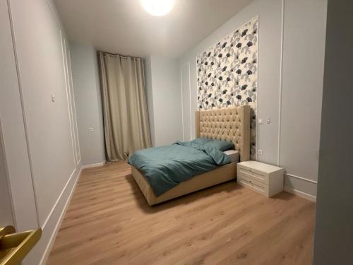 une chambre avec un lit et un parquet dans l'établissement Appartement 4 chambres, à Cholet