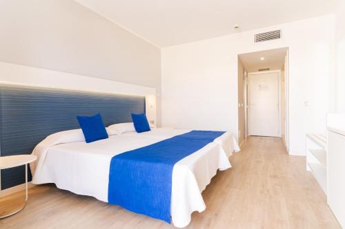 a bedroom with a large white bed with blue pillows at HOVIMA Costa Adeje - For Cool Adults in Adeje