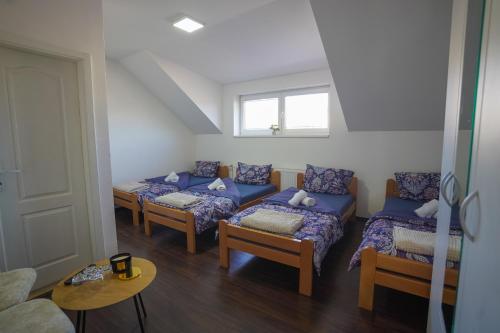 a room with four beds and a table and a window at Konačište Zlatiborski Put in Užice