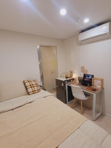 a bedroom with two beds and a desk with a computer at Stay Aall Seoul Train Station 2 in Seoul