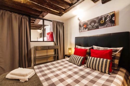 une chambre avec un grand lit avec des oreillers rouges dans l'établissement Opéra Paris center Charming air-conditioned loft, à Paris