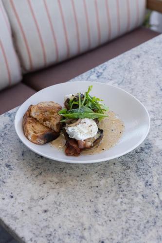 a white plate with food on a table at Latitude Aparthotel by Totalstay in Cape Town