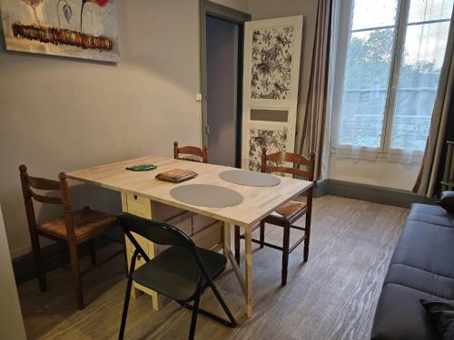 une table à manger avec des chaises et un canapé bleu dans l'établissement Le central 310, à Vittel